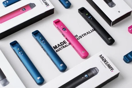 A collection of cheap vapes with a warning sign overlay, symbolizing potential risks.