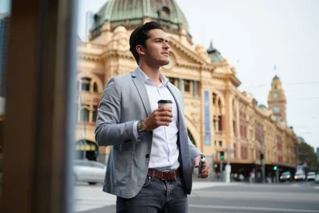 Stylish person using a vape disposable in a modern Australian urban setting.